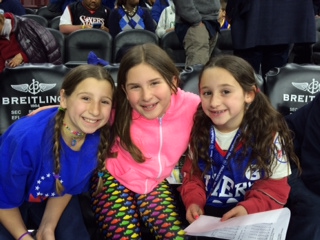 Misha Cohen, Ava Krasin and Kylie Rubin are court side at a 76ers game.